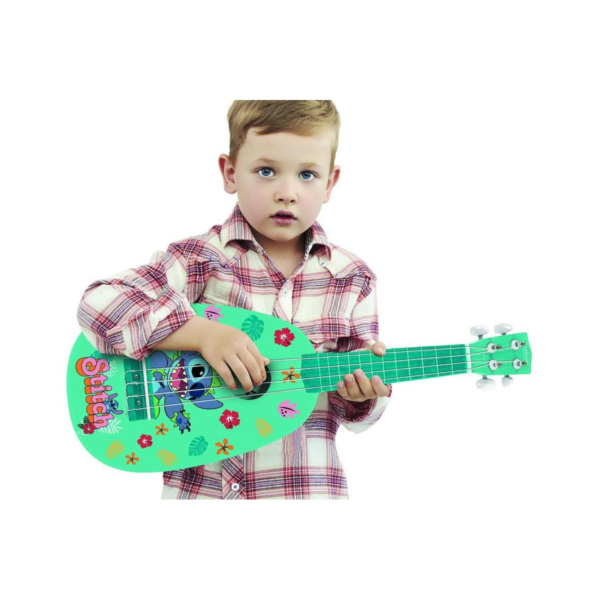 Mały chłopiec trzymający zielone ukulele Stitch z kwiatowymi i postaciowymi wzorami.