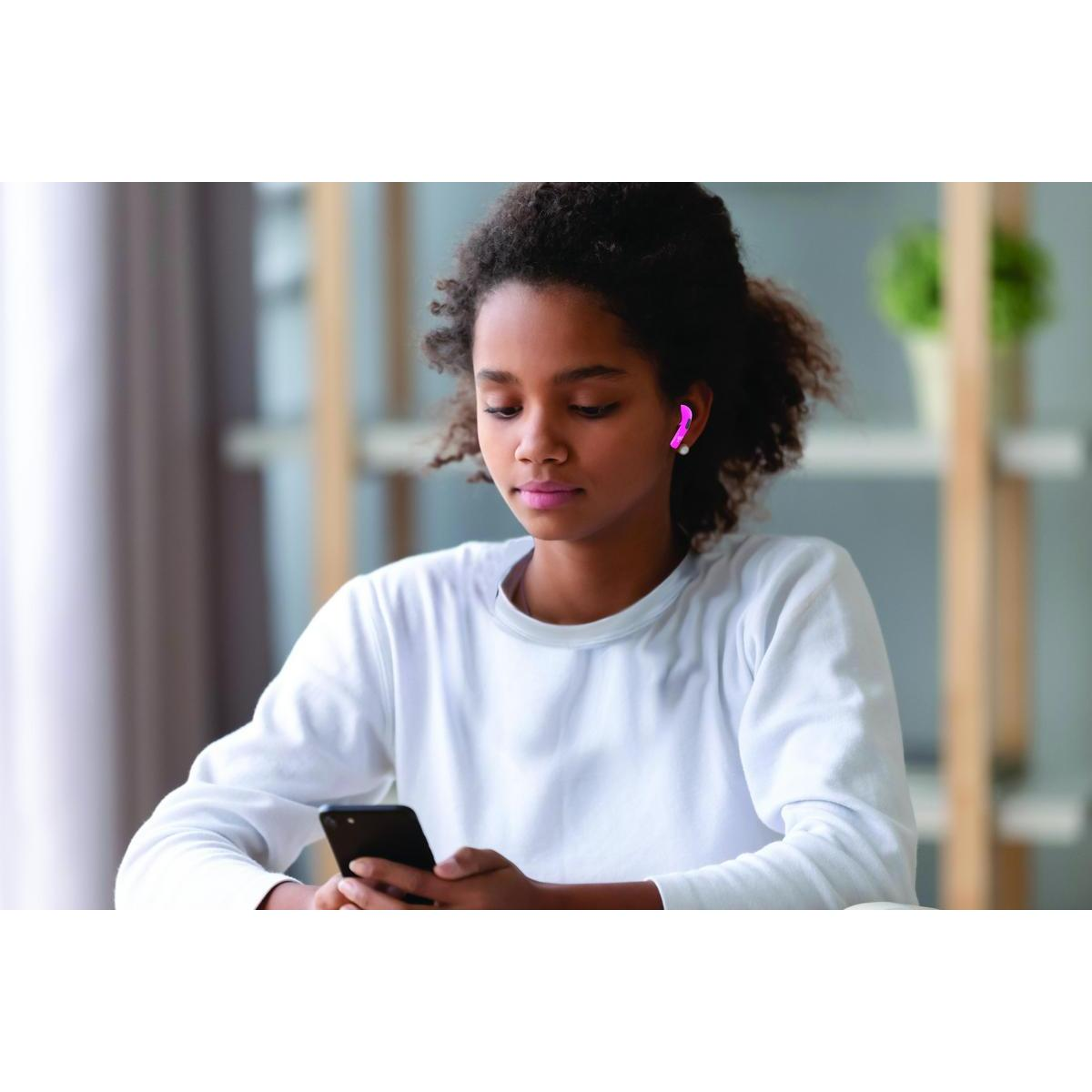 Chica con auriculares usando un teléfono. La chica tiene auriculares y está mirando el teléfono.