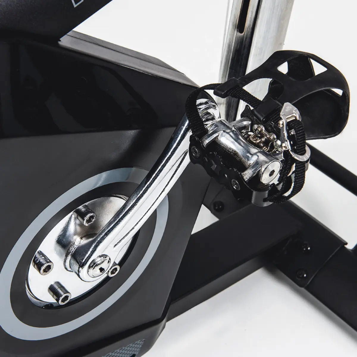 Nahaufnahme eines stationären Fahrradpedals. Chrompedal, schwarze Akzente, weißer Hintergrund.
