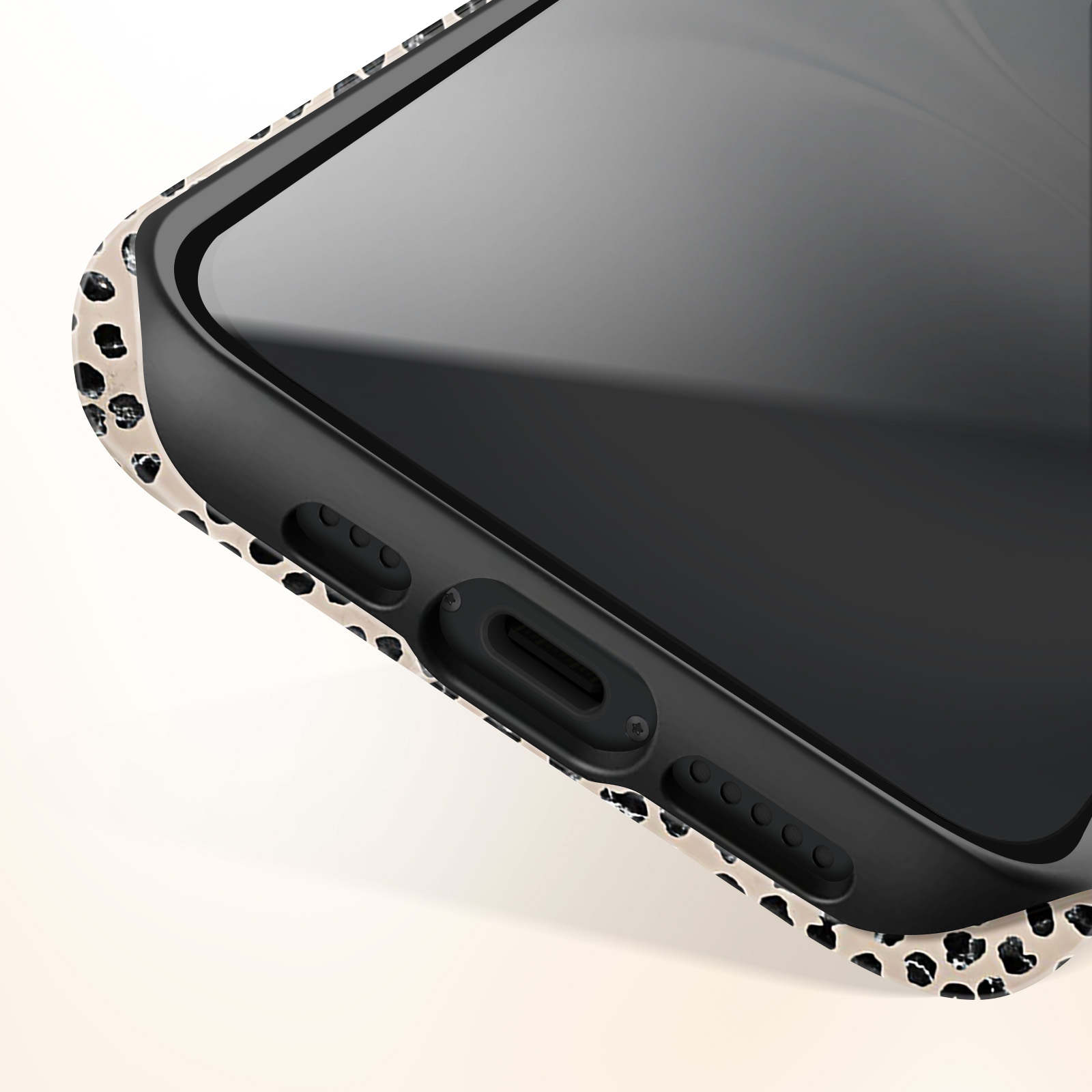 Close-up van een telefoon met zwart scherm en gespikkelde hoes.