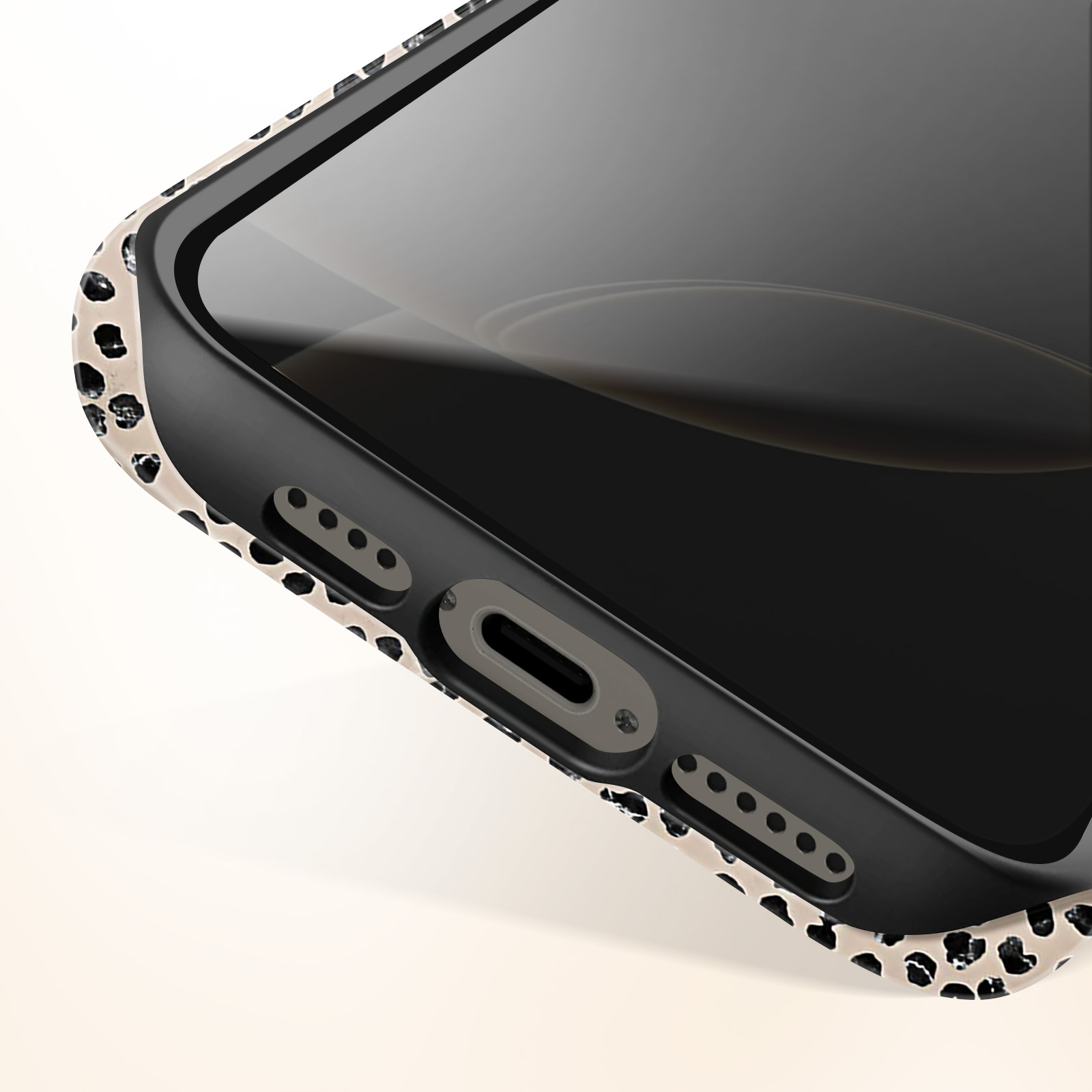 Close-up van een telefoonhoesrand met een zwarte telefoon erin. De hoes is patroon.