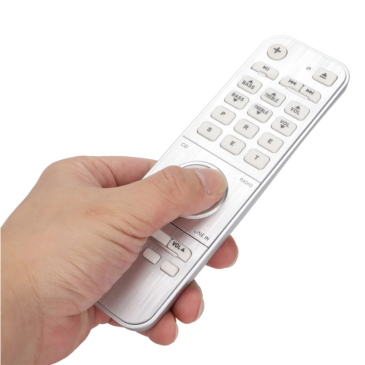 Eine Hand hält eine silberne Fernbedienung mit Knöpfen, weißer Hintergrund.