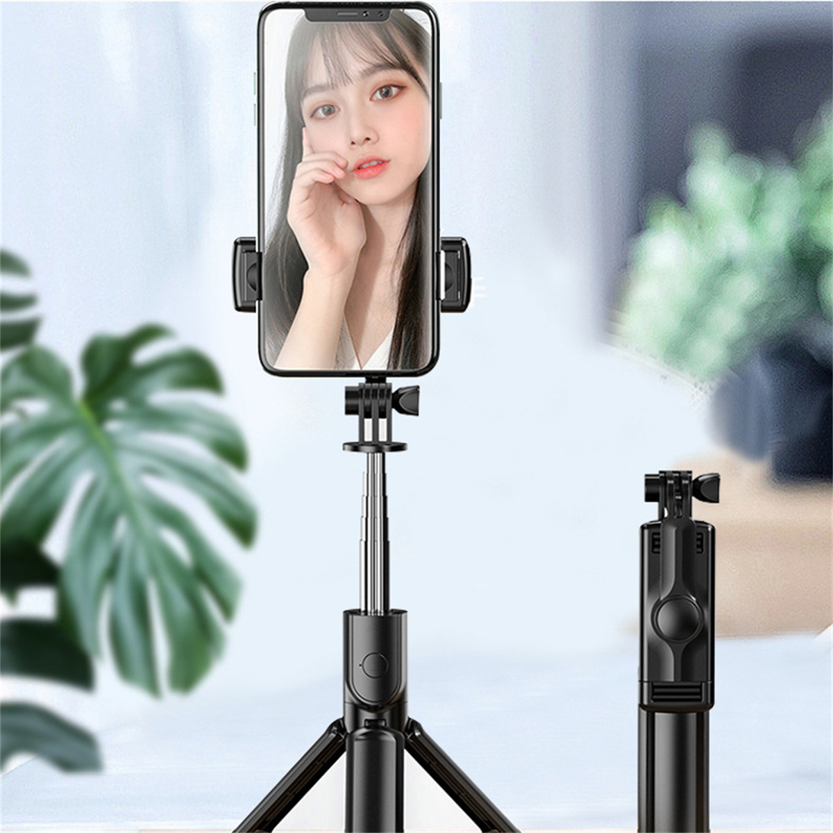 Selfie-Stick mit befestigtem Telefon. Das Telefon zeigt eine Frau. Schwarzer Stick und Stativ. Hintergrund: weiß.