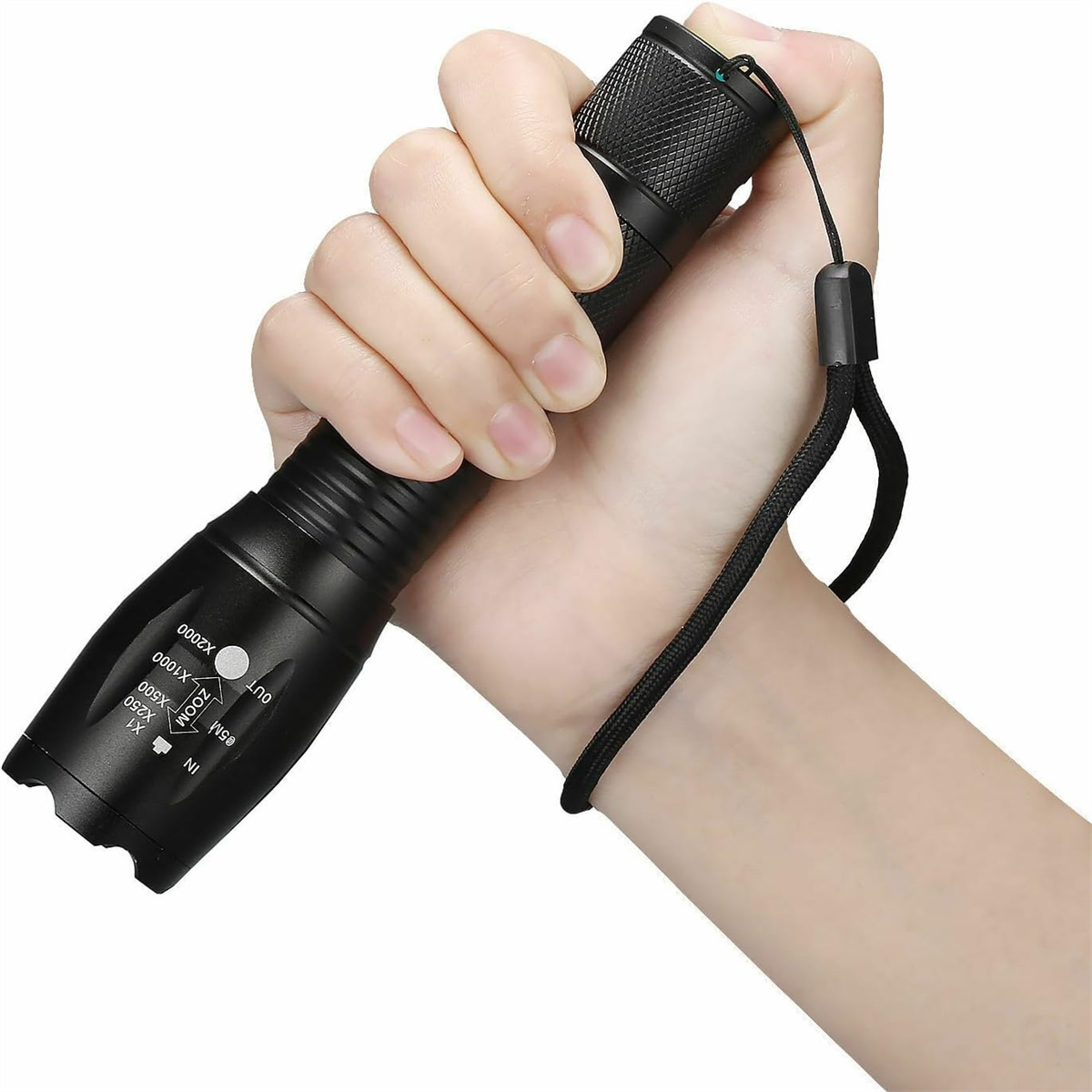 Hand hält eine schwarze Taschenlampe. Sie hat eine Handschlaufe und ein Einstellrad.