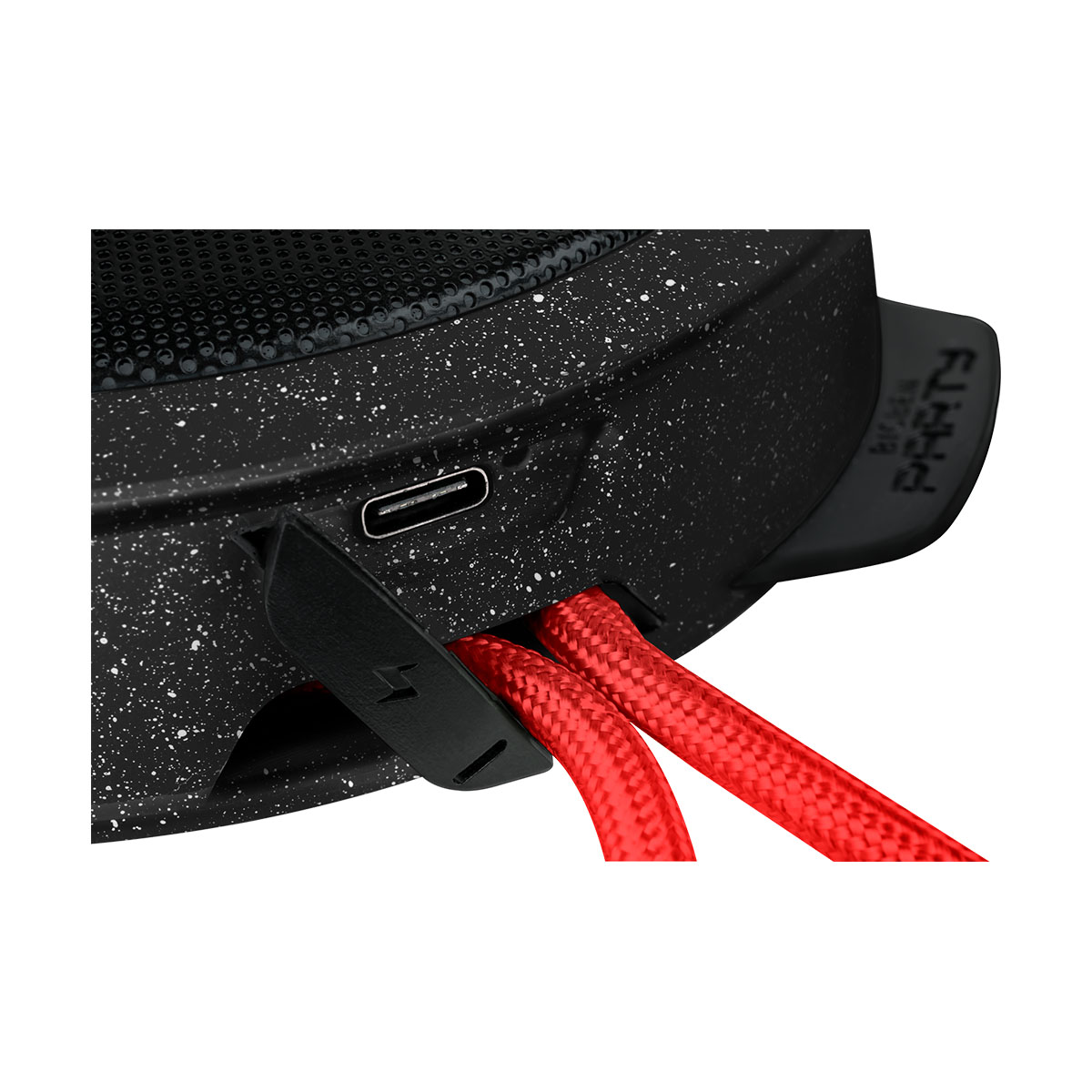 Zbliżenie czarno-białego głośnika, pokazujące port ładowania i czerwone kable.