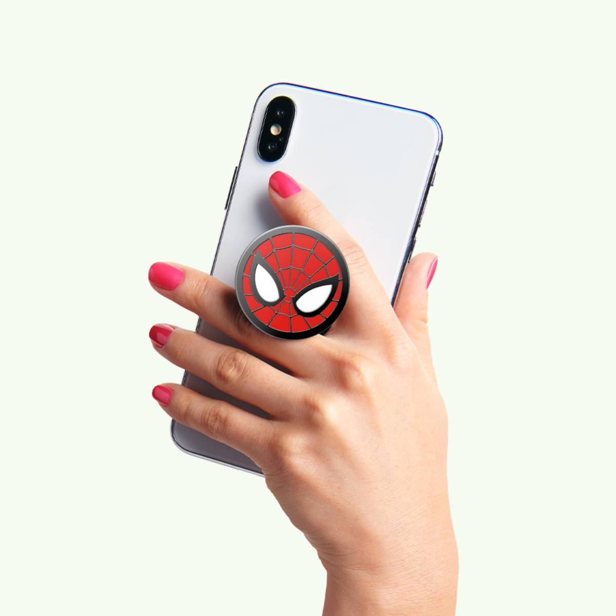 Mano che tiene un telefono con un pop socket di Spider-Man. Design rosso e nero. Unghie dipinte di rosa.