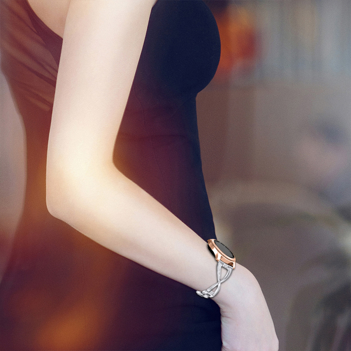 Der Arm einer Frau mit einer roségoldenen Smartwatch. Die Uhr hat einen schwarzen Bildschirm und ein silbernes Band.
