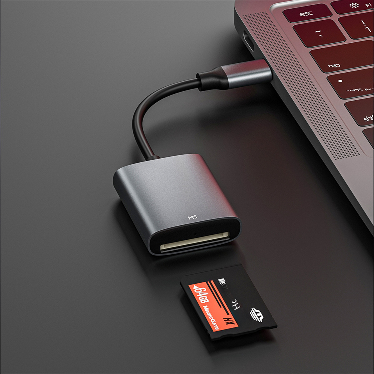 Ein silberner Kartenleser, der an einen Laptop angeschlossen ist. Eine Speicherkarte liegt daneben.