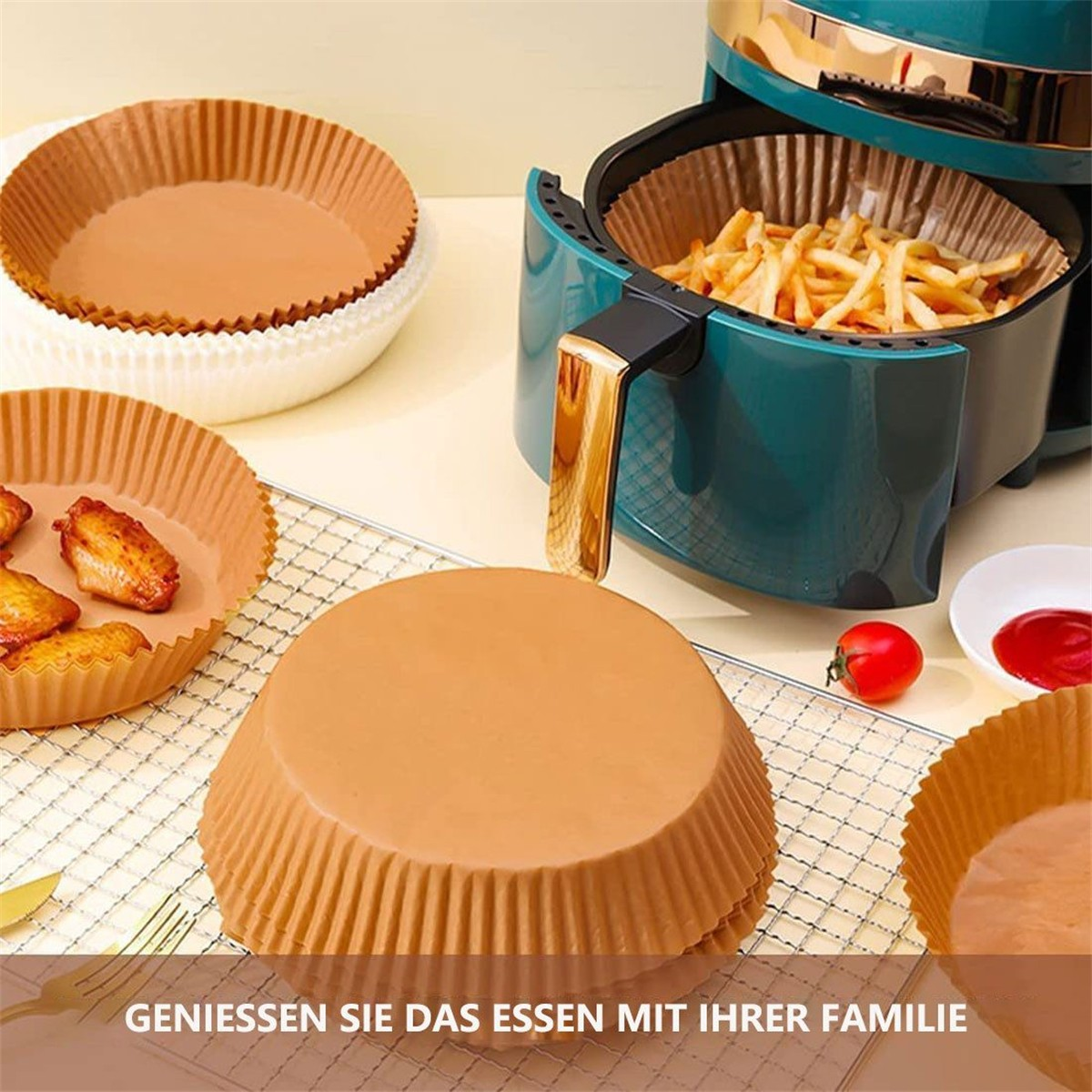 Heißluftfritteuse mit Essen und Papiereinlagen. Die Fritteuse ist türkis, mit Essen drin.