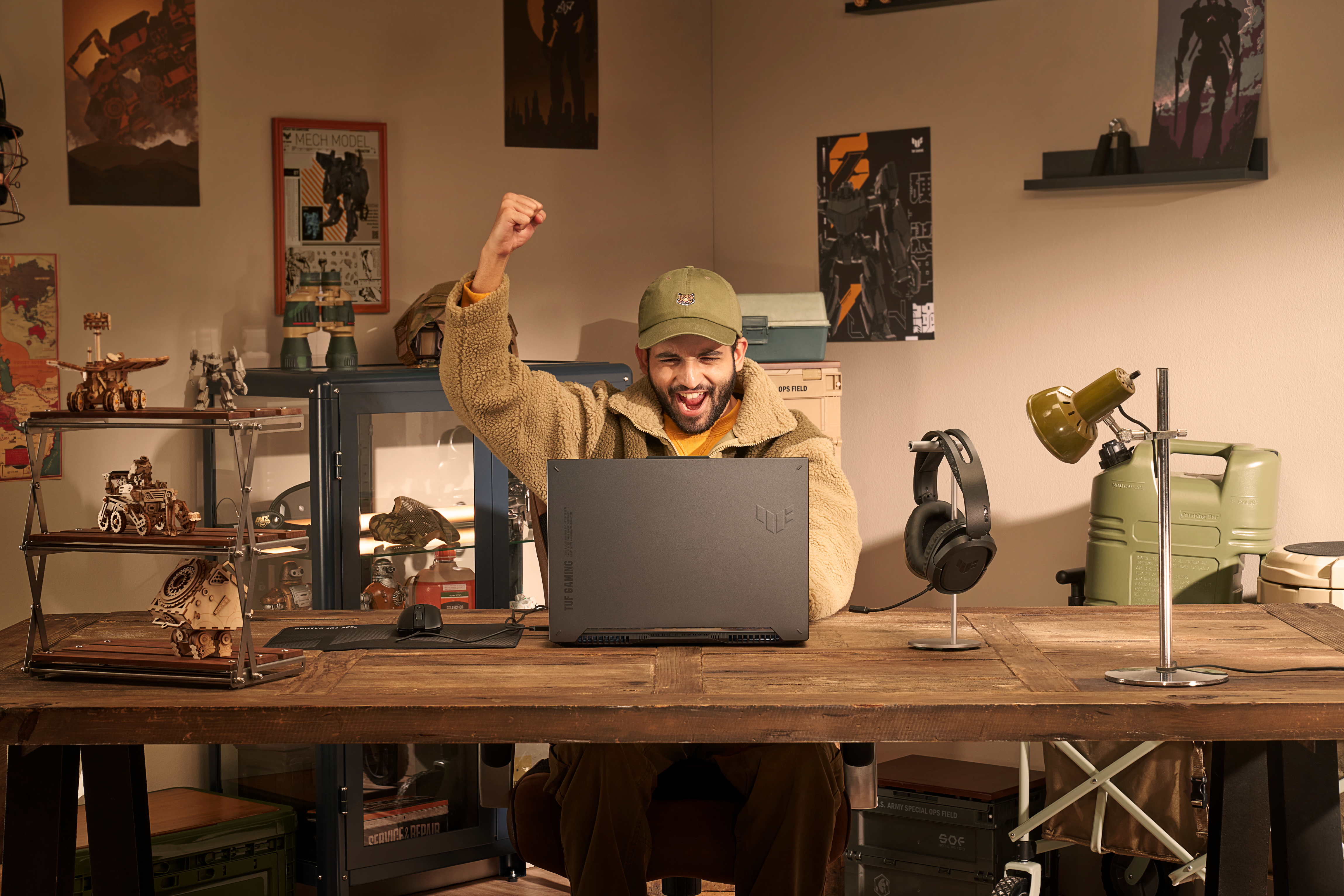 Mann jubelt beim Spielen auf einem Laptop. Zimmer mit Dekorationen.