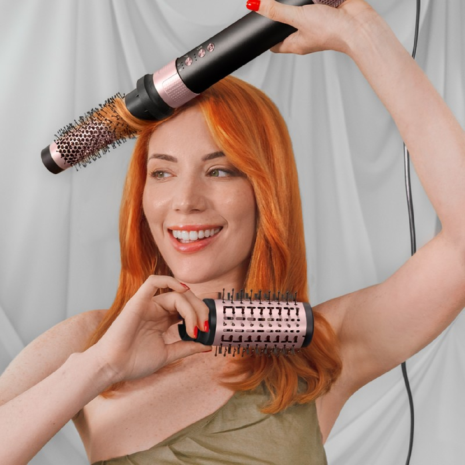 Donna con capelli rossi tiene due strumenti per lo styling. Uno sopra la testa, l'altro in mano.