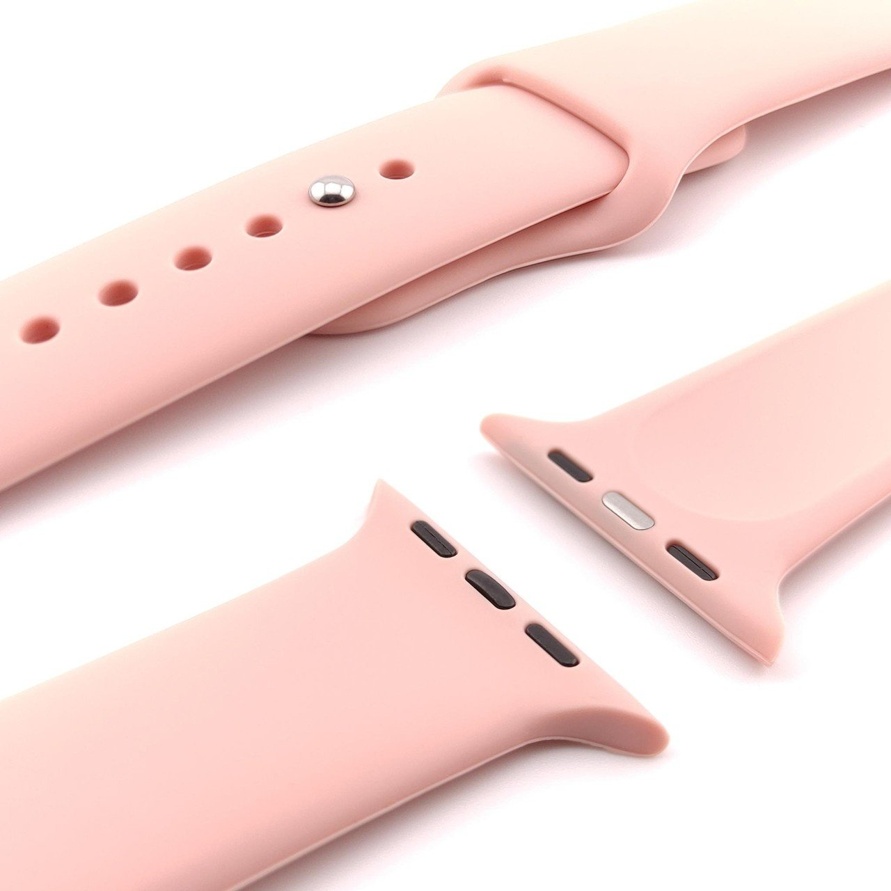 Nahaufnahme von hellrosa Uhrenarmbandkomponenten, abgetrennt, auf Weiß. Glattes, geschwungenes Design.