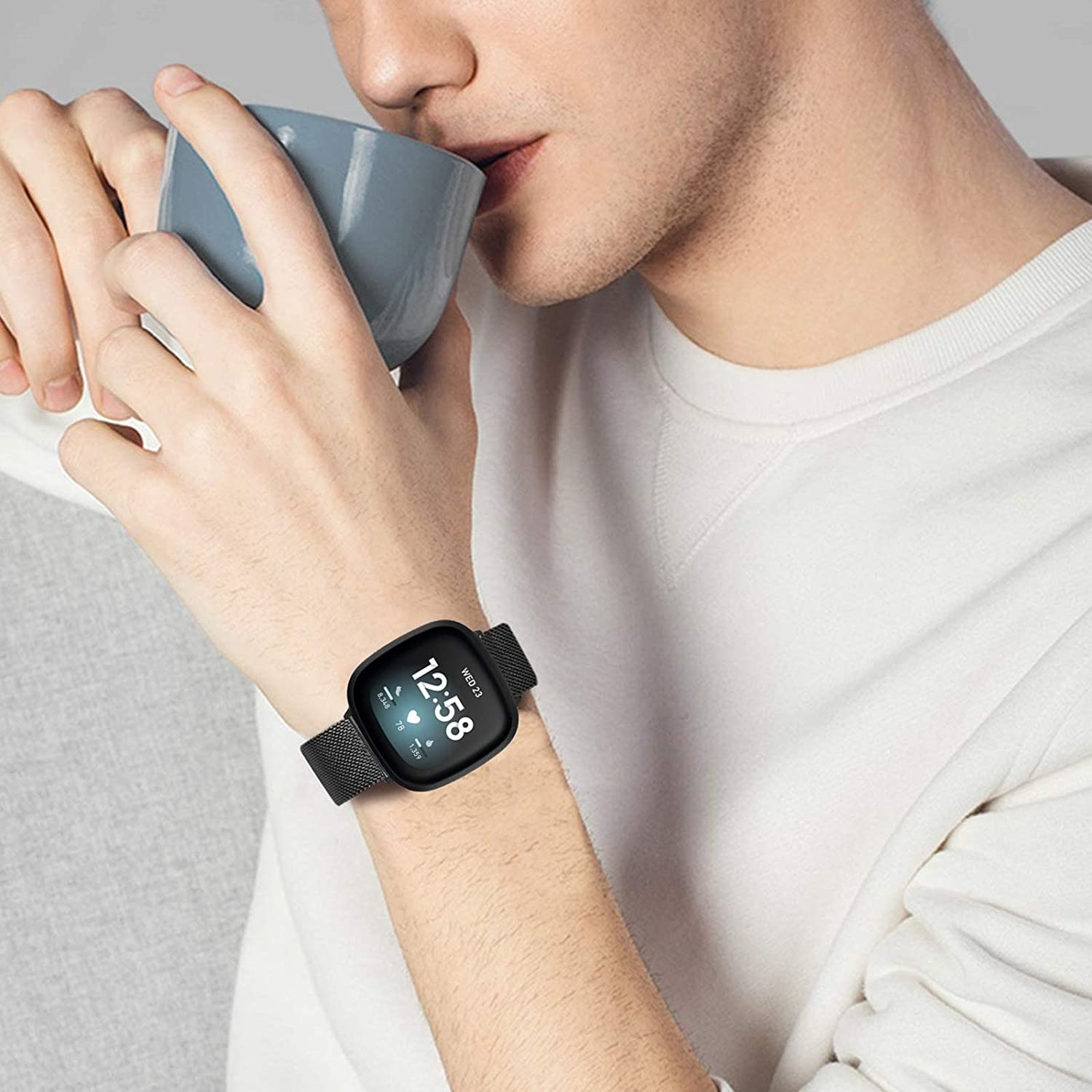 Person trägt eine schwarze Smartwatch, liest Uhrzeit und Datum ab.