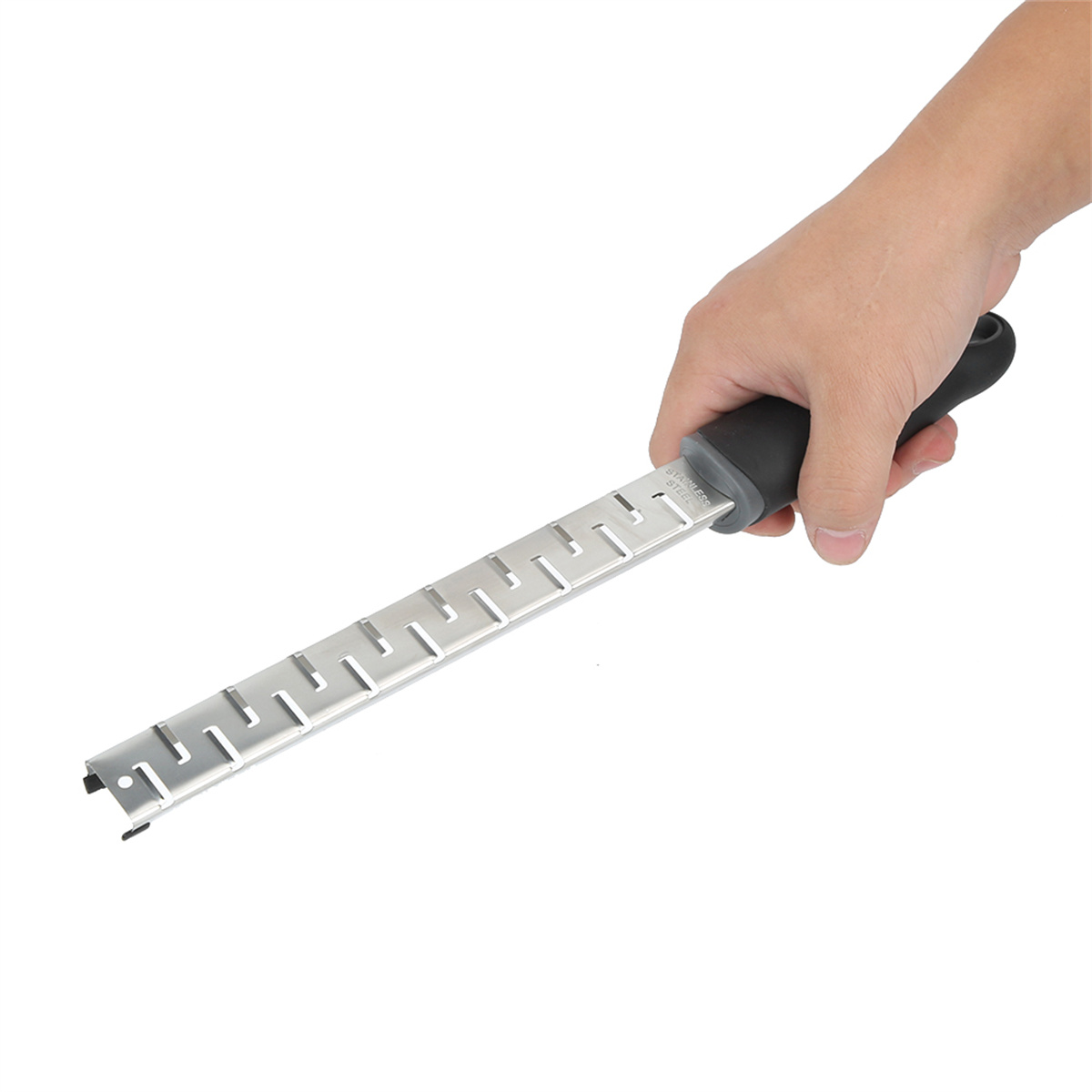 Eine Hand hält eine Reibe. Die Reibe ist aus Edelstahl mit schwarzem Griff.