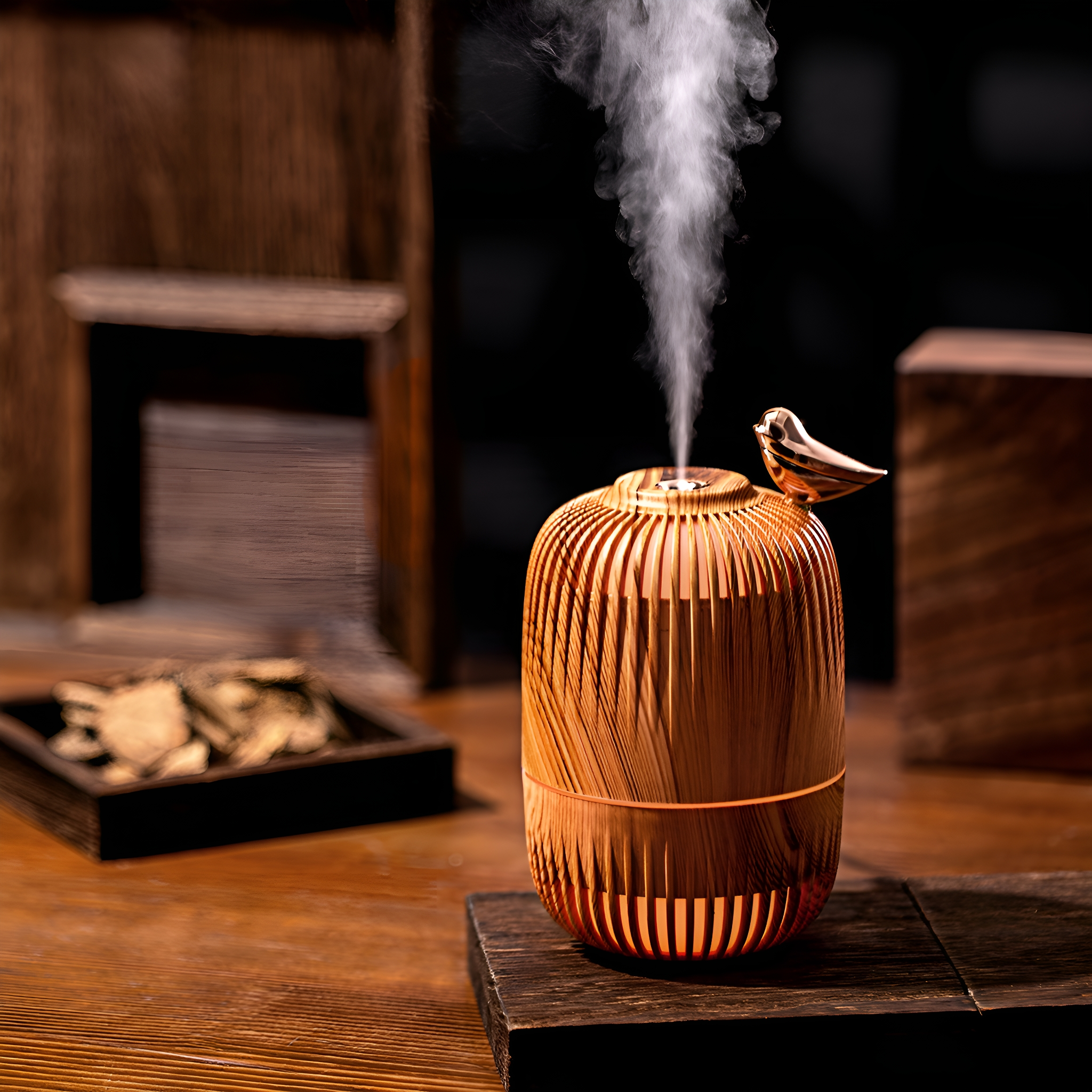 Holz-Aromadiffusor mit Dampf, neben Holzstücken und einer schwarzen Schale.