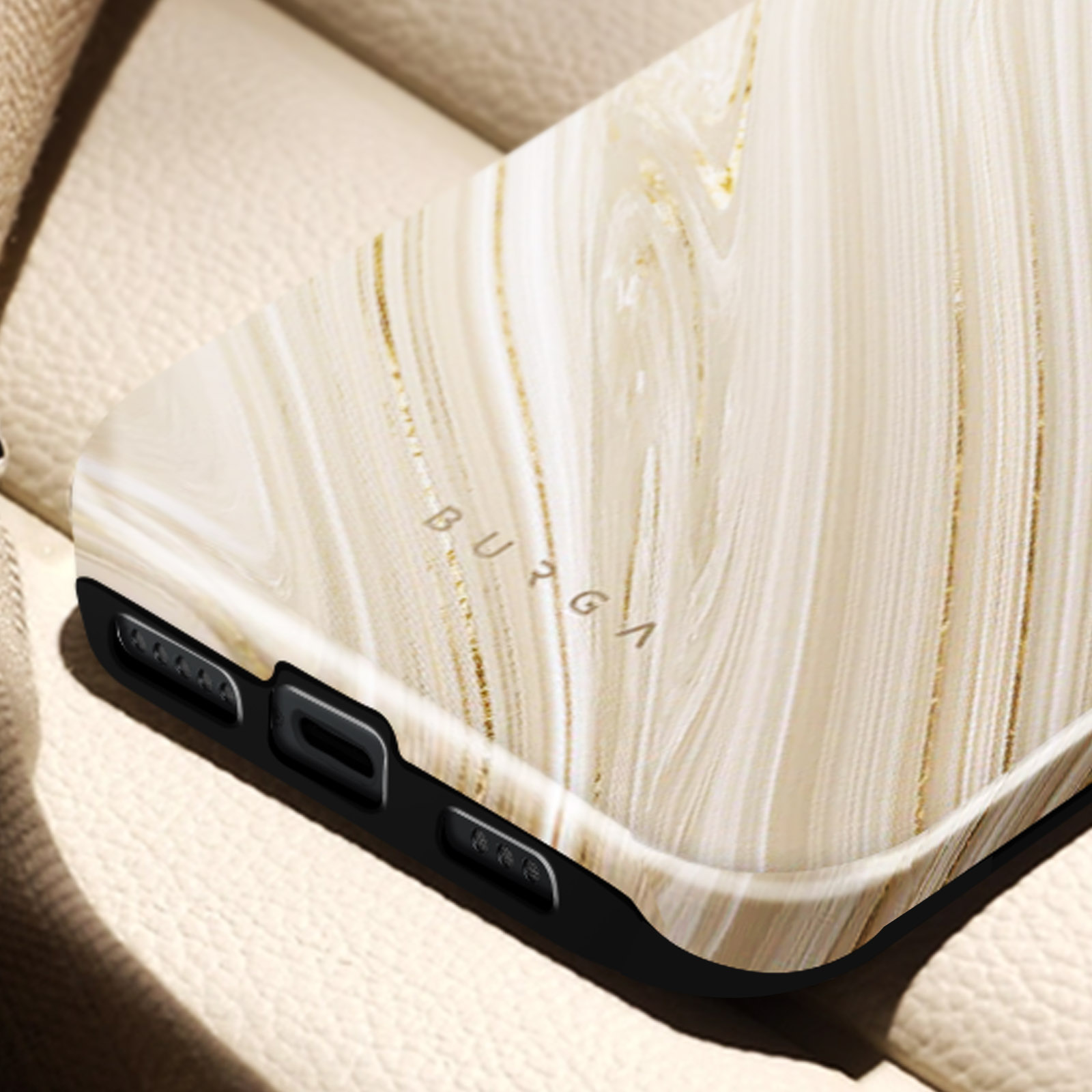 Close-up of a phone case with a marble design. The case is beige with gold streaks, and the brand is BURGA.
