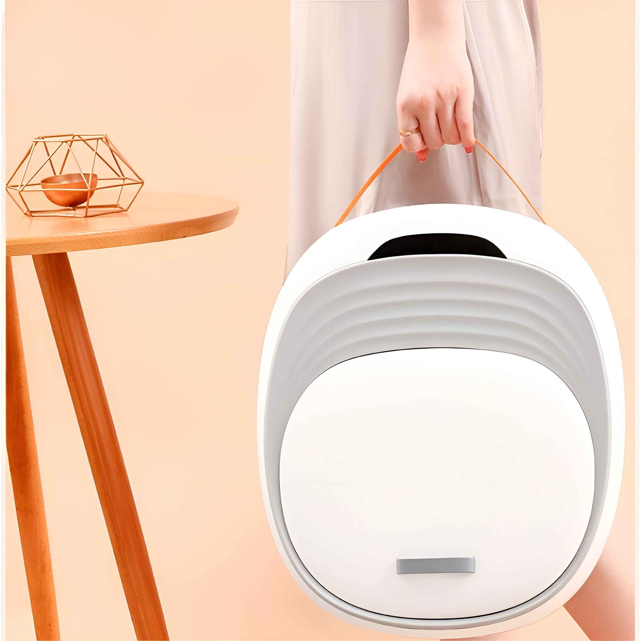 Eine Person hält ein weißes, oval geformtes Produkt mit einem orangefarbenen Griff.