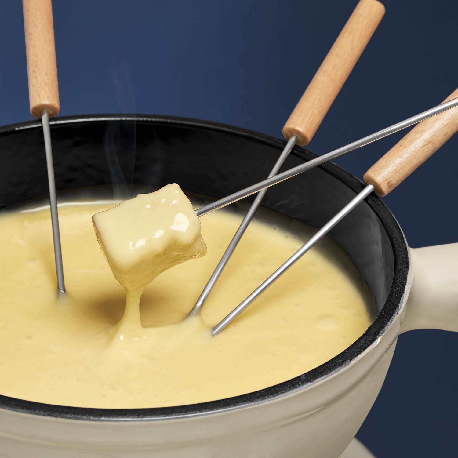 Pentola per fonduta con formaggio, un pezzo di formaggio tenuto da una forchetta.