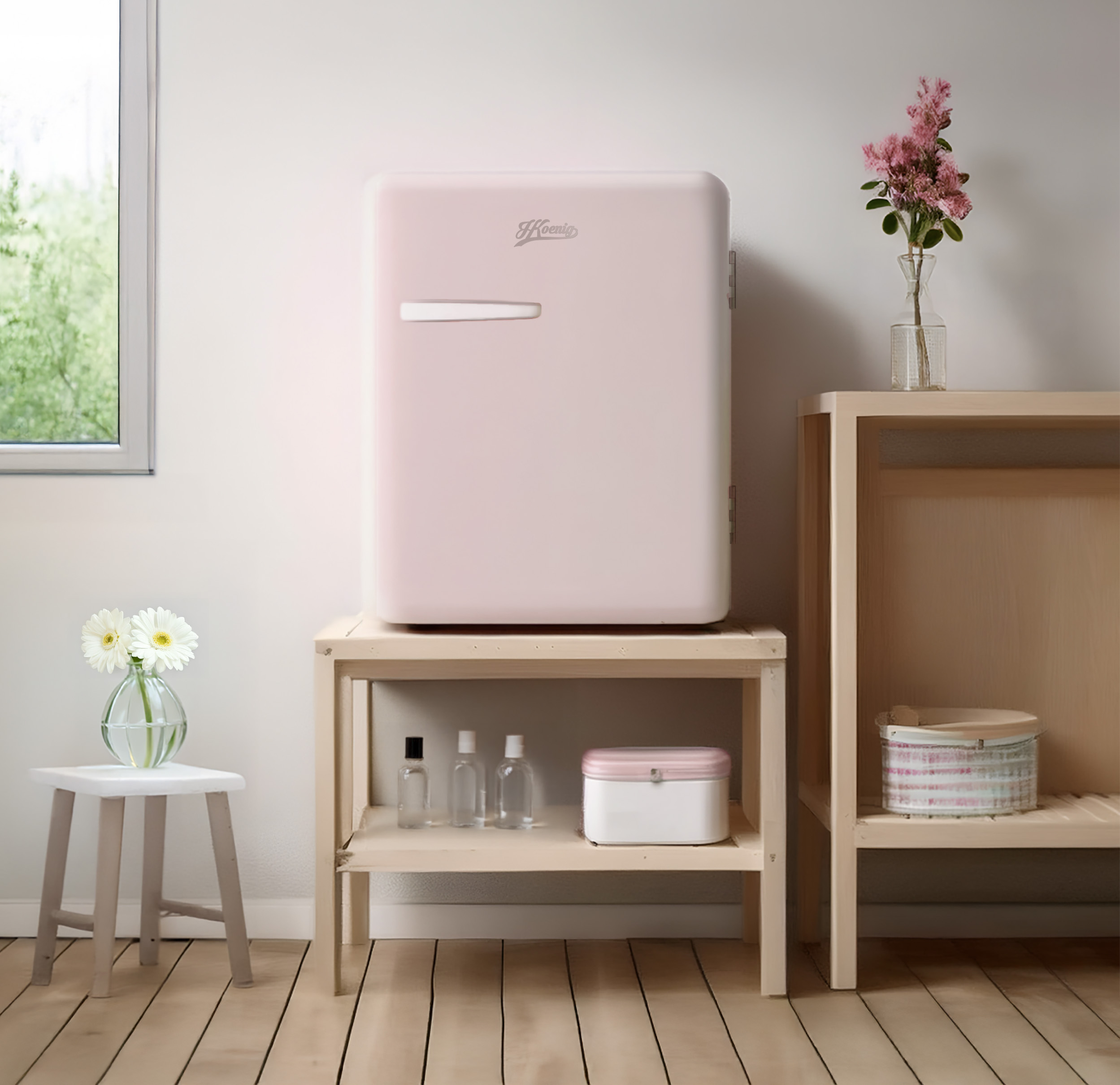 Mini-frigo rosa su mensola in legno con oggetti. Muro bianco e pavimento in legno.
