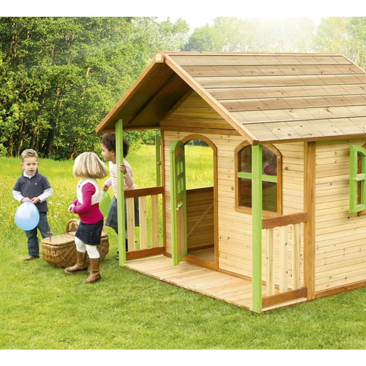 Kinder spielen in einem hölzernen Spielhaus in einem grünen Garten. Das Haus hat grüne Verzierungen.