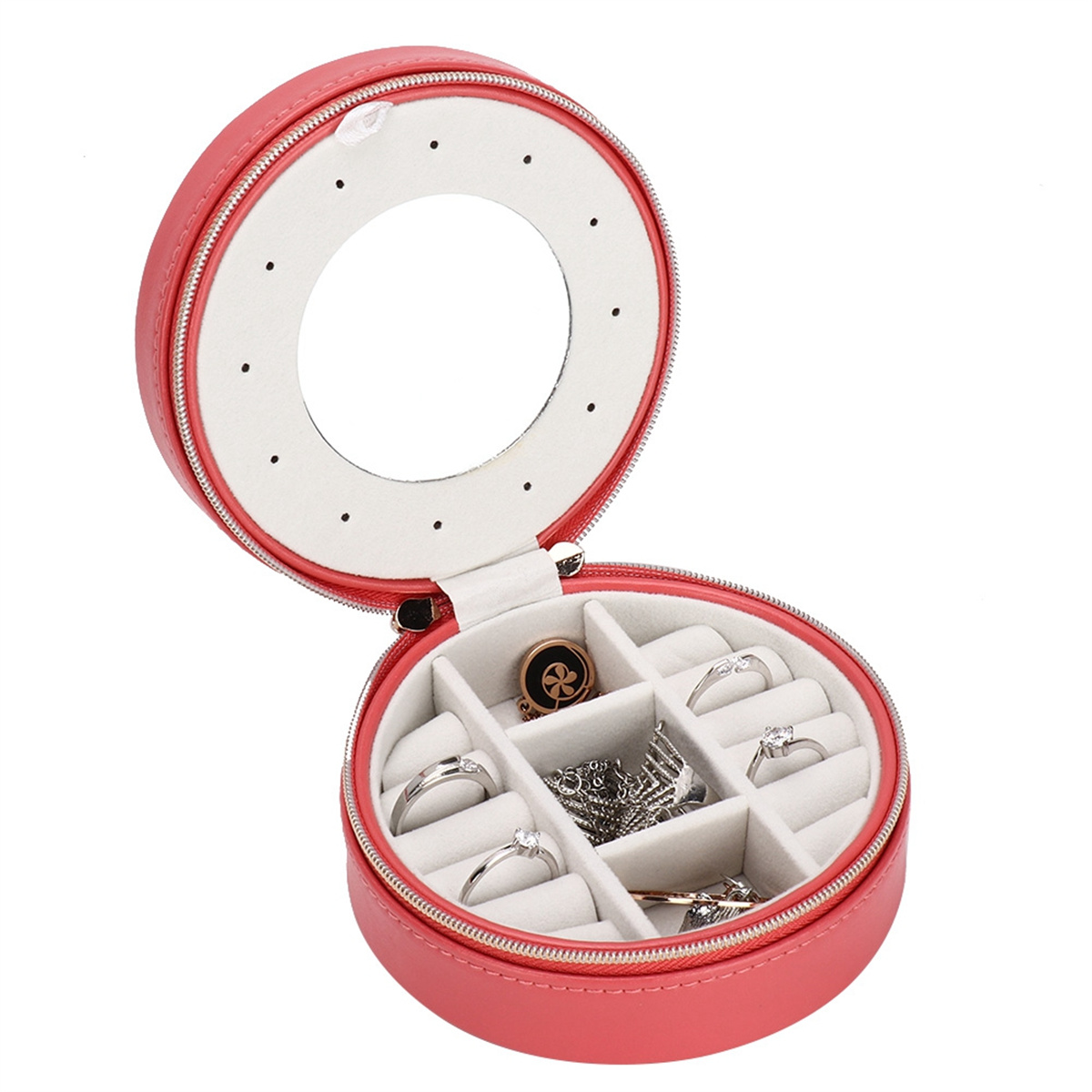 Eine pinke, offene Schmuckschatulle mit Ringen und Schmuckstücken. Runder Spiegel oben.