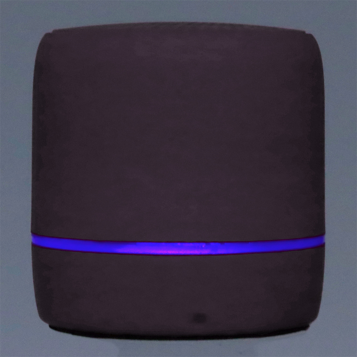 Ein dunkler zylindrischer Luftbefeuchter mit blauem Lichtband.