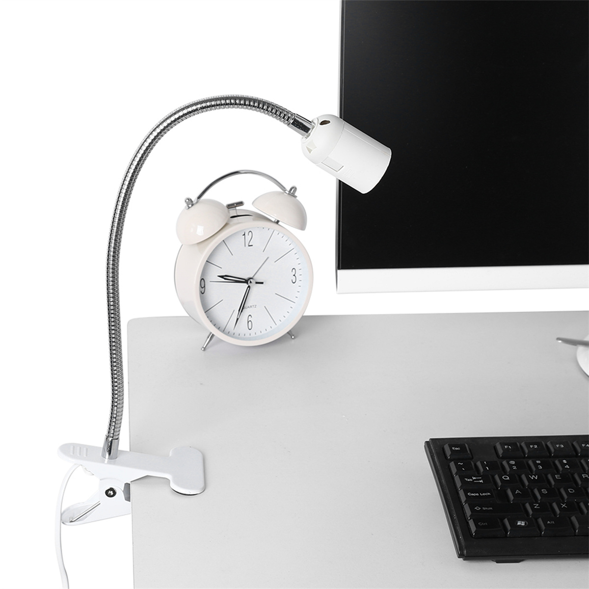 Schreibtischlampe mit flexiblem Hals. Weißer Wecker und Monitor auf dem Schreibtisch.