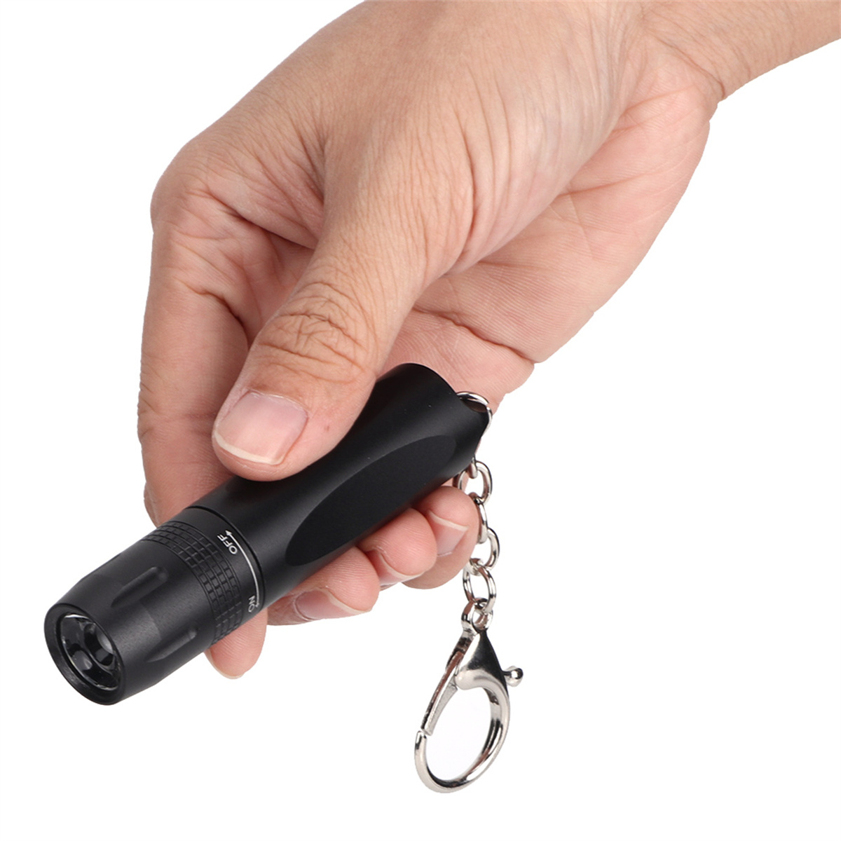 Eine schwarze Schlüsselanhänger-Taschenlampe, die in einer Hand gehalten wird.