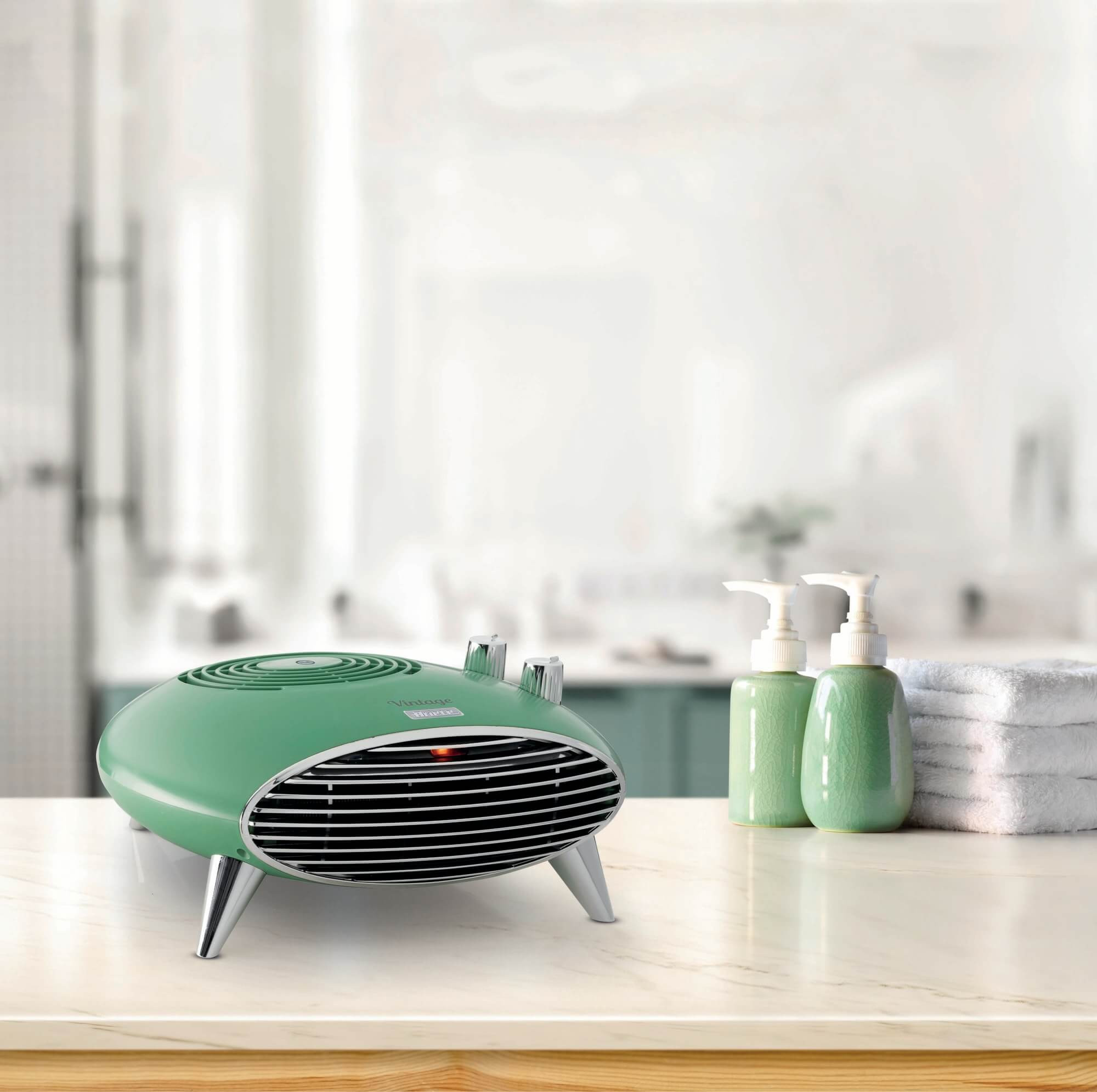 Retro grzejnik w kolorze zielonym na stole z butelkami i ręcznikami, rozmyte tło.