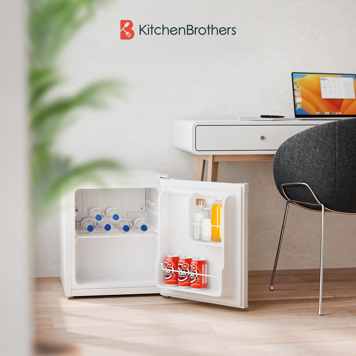 Witte mini-koelkast open met drankjes erin, op houten vloer. Bureau, laptop en plant in BG.