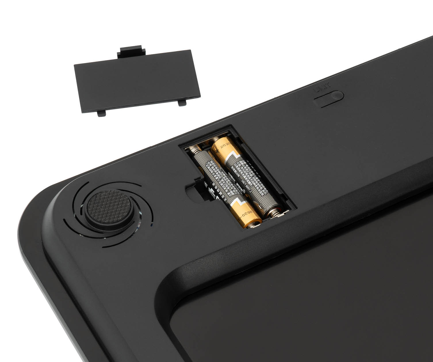 Close-up of the battery compartment of a black scale with batteries and open cover.