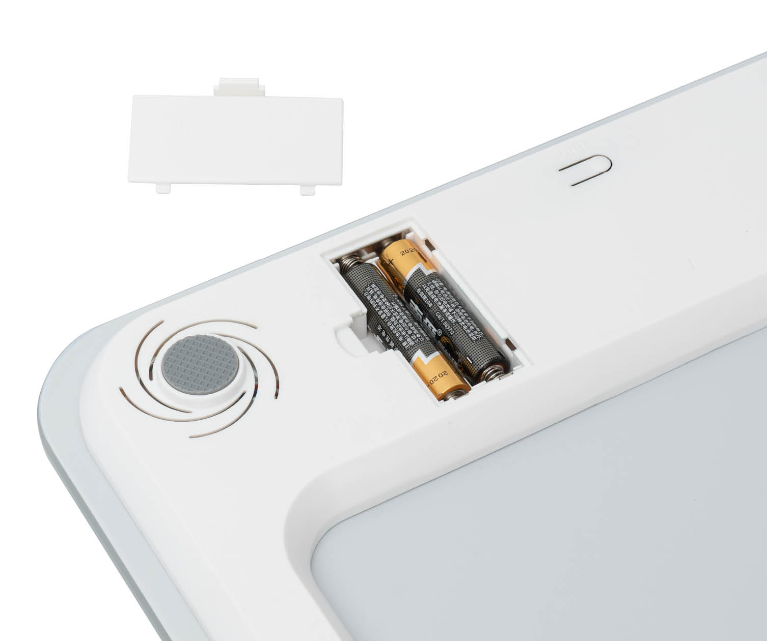 White device with batteries inside, top removed, showing battery compartment.