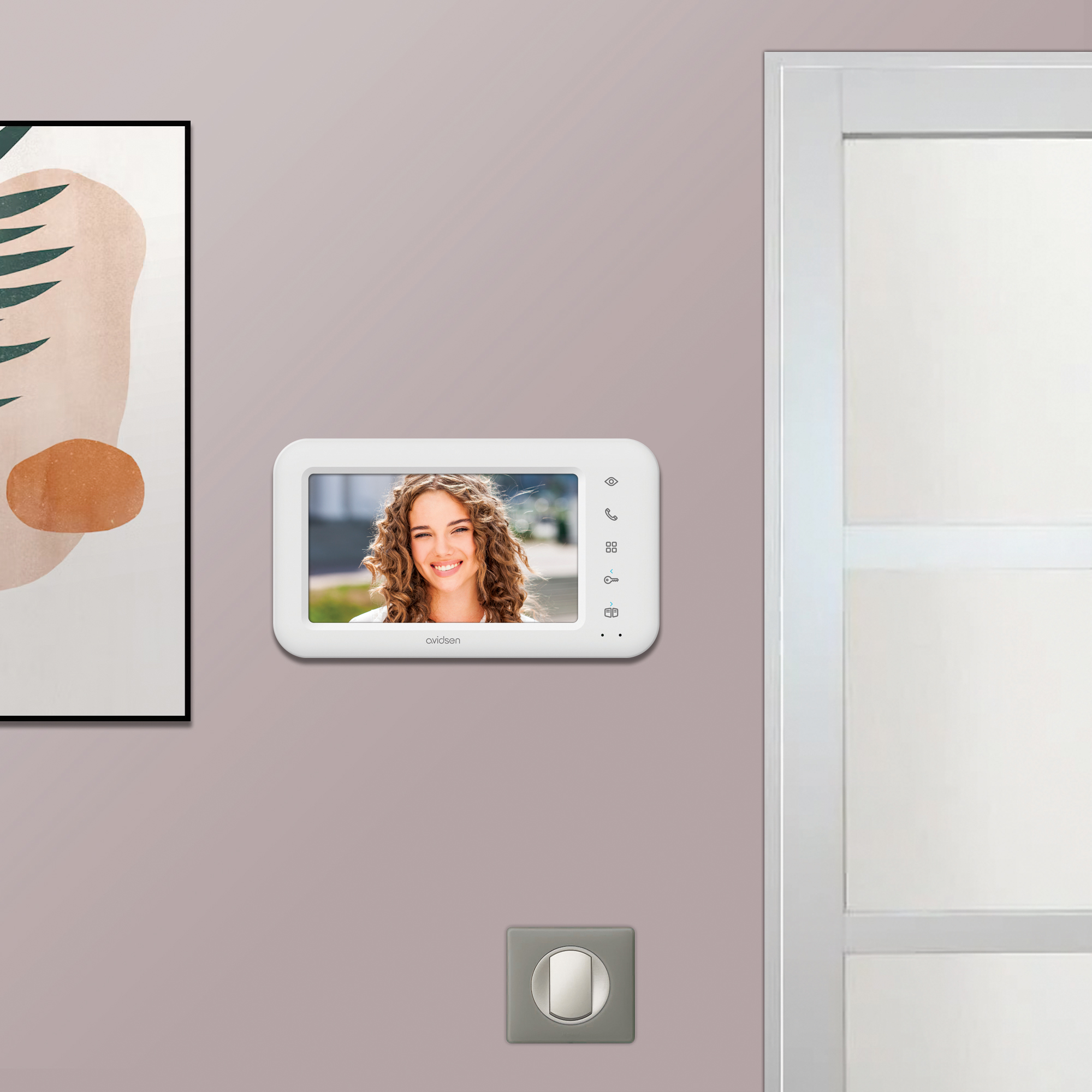 Un videoportero montado en la pared que muestra el rostro de una mujer sonriente.