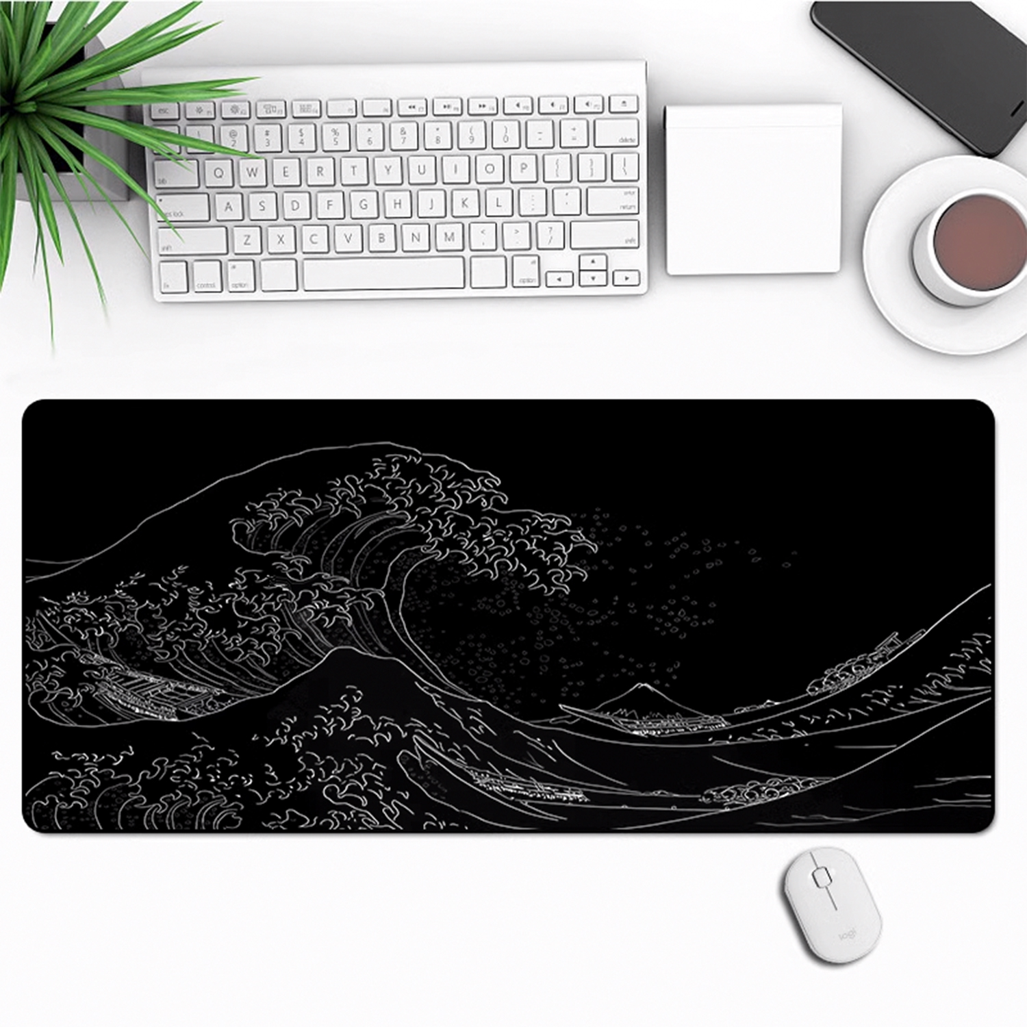 Czarna podkładka pod mysz z białym wzorem fal, biała klawiatura i mała zielona roślina na białym biurku.