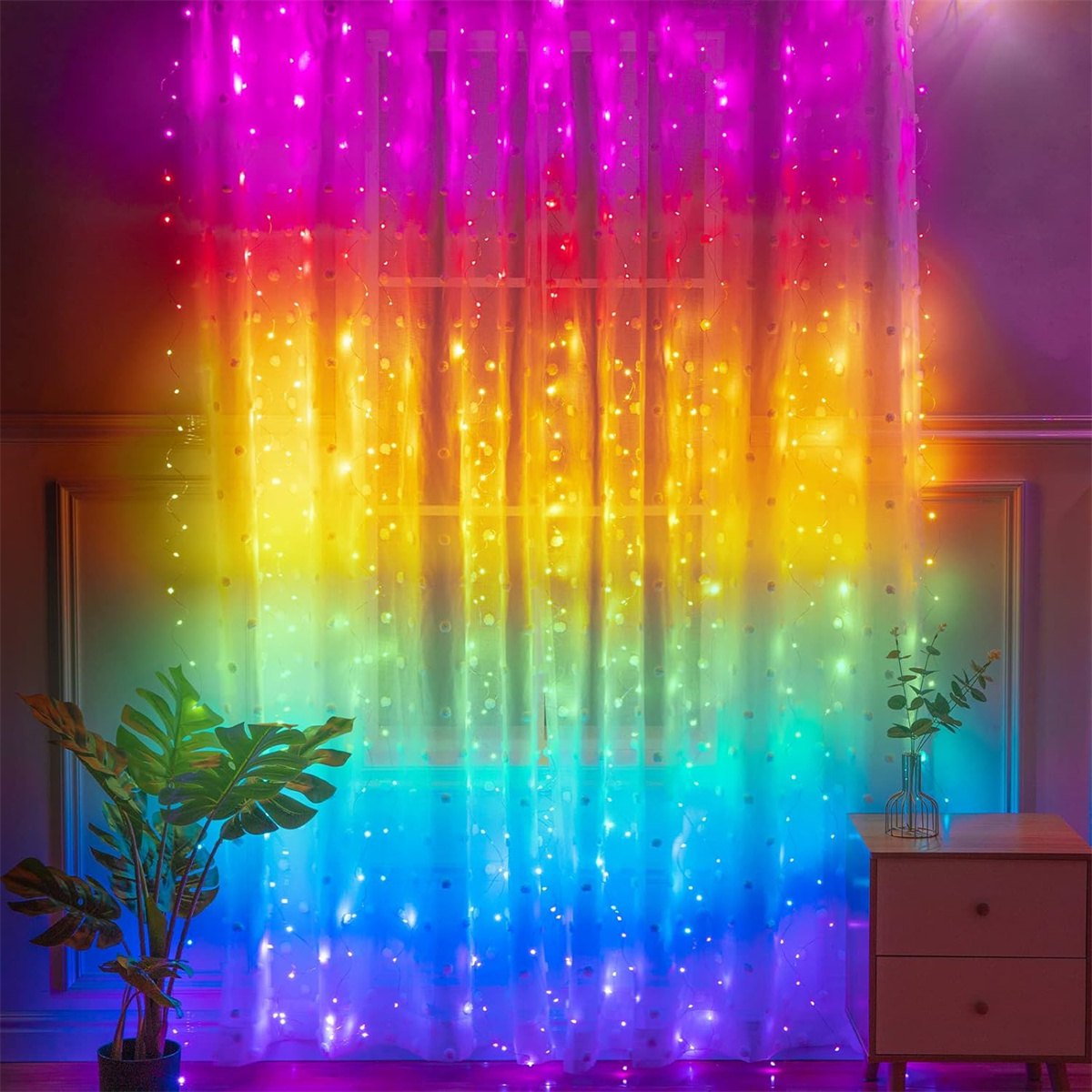 Vorhänge mit bunten Lichtern. Eine Pflanze und ein Nachttisch befinden sich im Vordergrund. Lichter erzeugen Regenbogeneffekt.