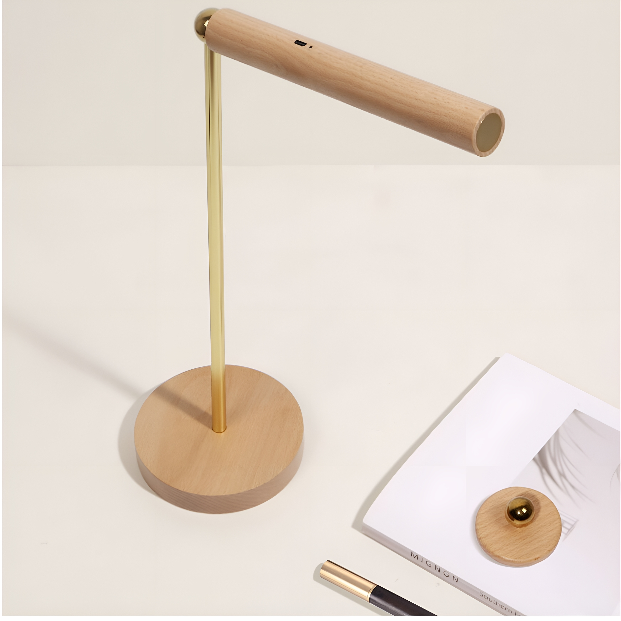 Eine Holzschreibtischlampe mit goldenem Schaft und Holzsockel, mit Buch und Stift.