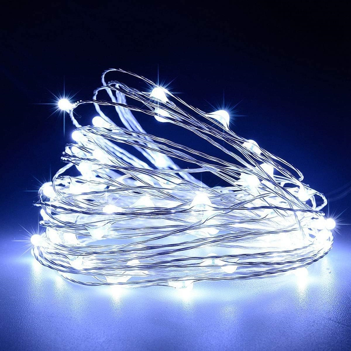 Ein Haufen weißer LED-Lichterketten. Die Lichter sind an und beleuchten einen dunkelblauen Hintergrund.