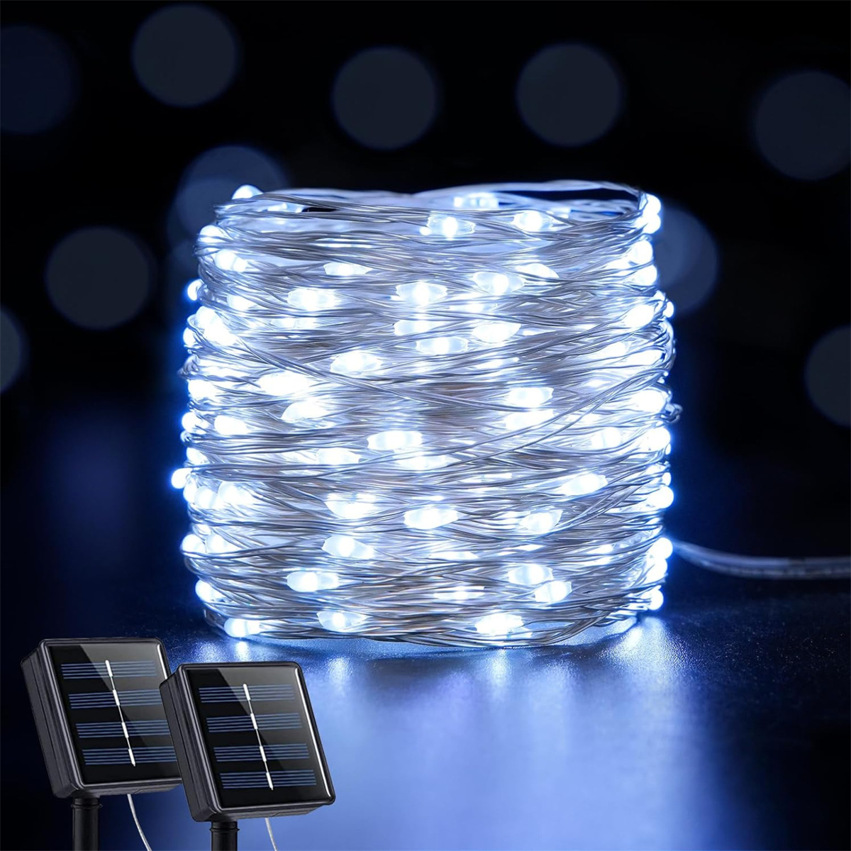 Eine aufgerollte Schnur mit weißen LED-Leuchten mit zwei Solarpanels auf schwarzem Untergrund.