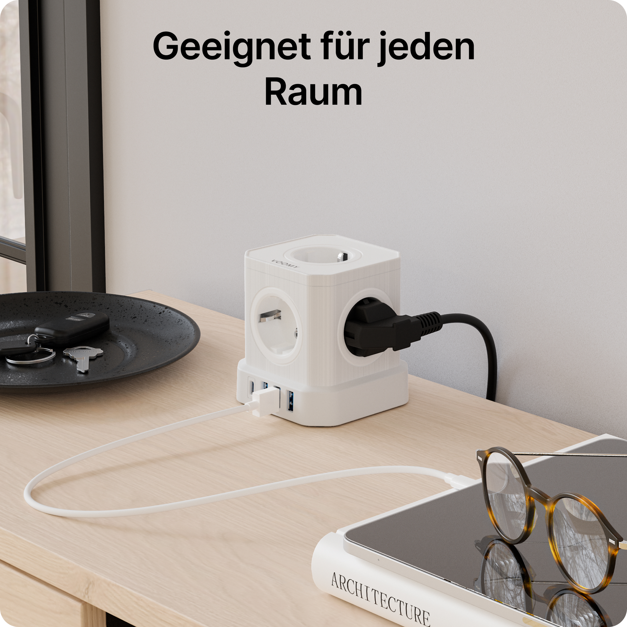 Biała kostka zasilająca z gniazdami i portami USB na stole z kluczami i okularami.