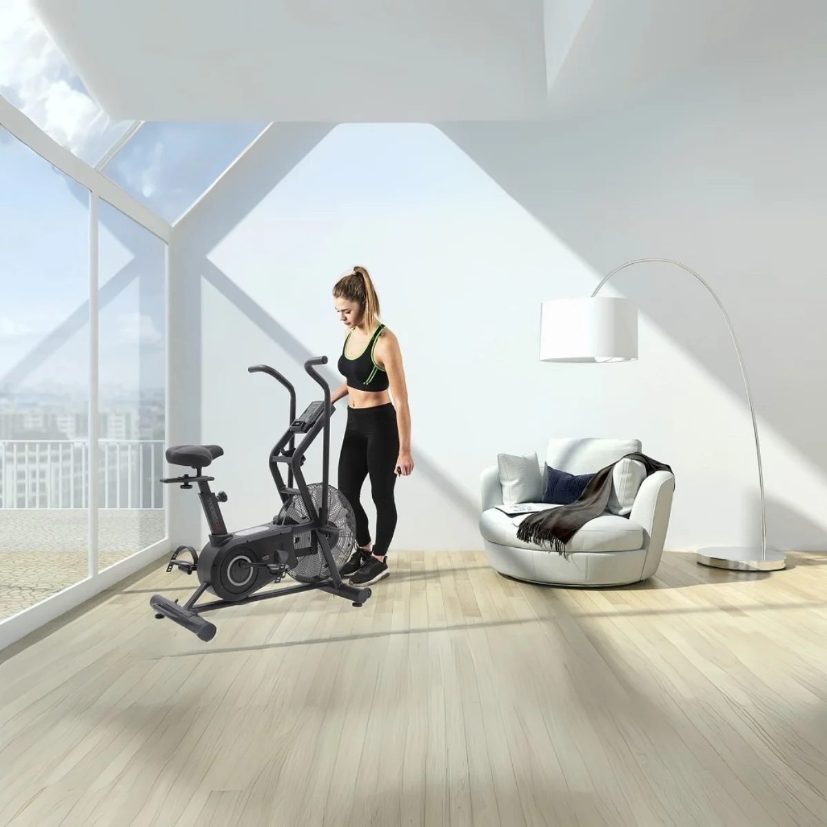 Een vrouw staat naast een airbike in een kamer met grote ramen, een witte stoel en een vloerlamp.