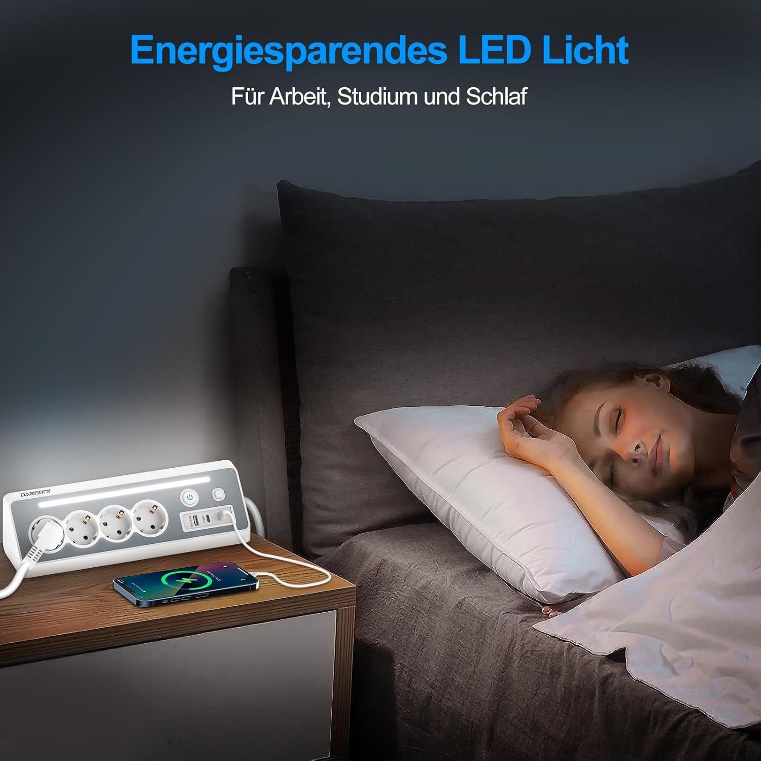 Eine schlafende Frau im Bett neben einem Nachttisch mit Steckdosenleiste und Telefon.