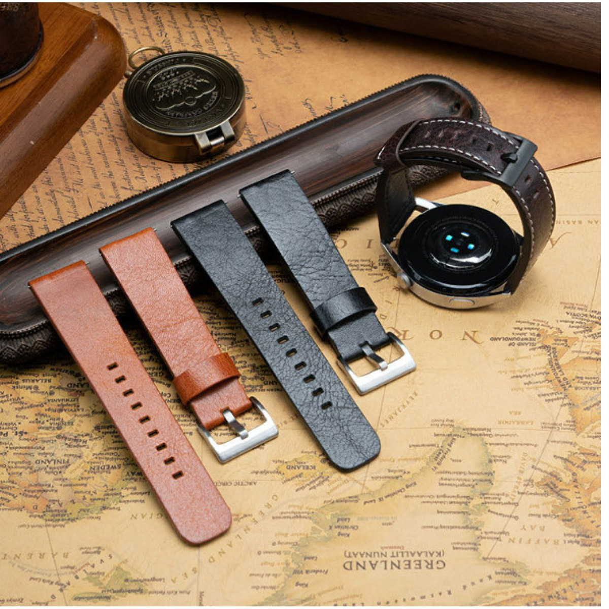 Armbänder aus braunem und schwarzem Leder, mit einem Zifferblatt und einem Kompass auf Kartenhintergrund.