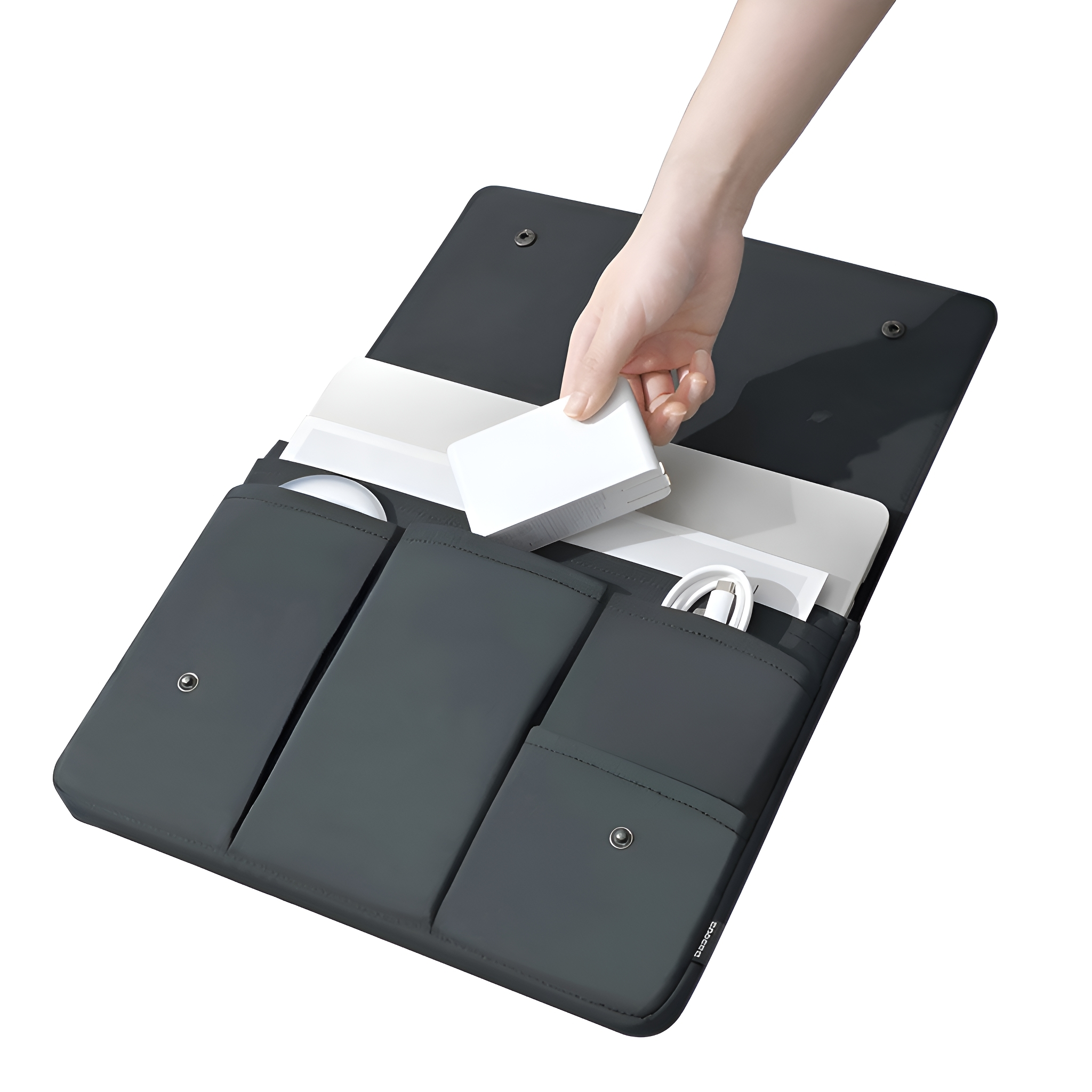 Eine Hand, die ein weißes Ladegerät in eine schwarze Laptoptasche mit Taschen legt.