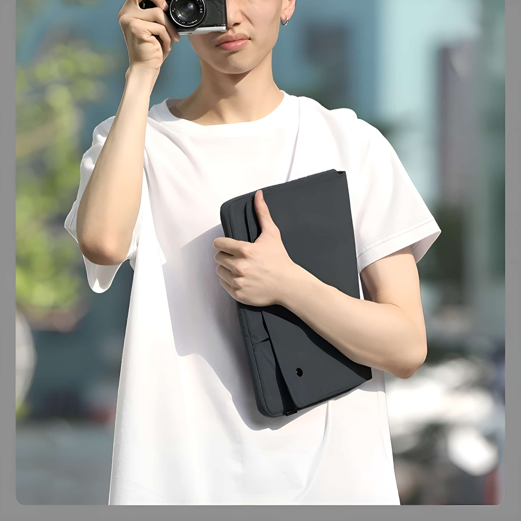 Eine Person macht ein Foto mit einer Kamera. Sie halten eine schwarze Hülle mit einem Knopf darauf.