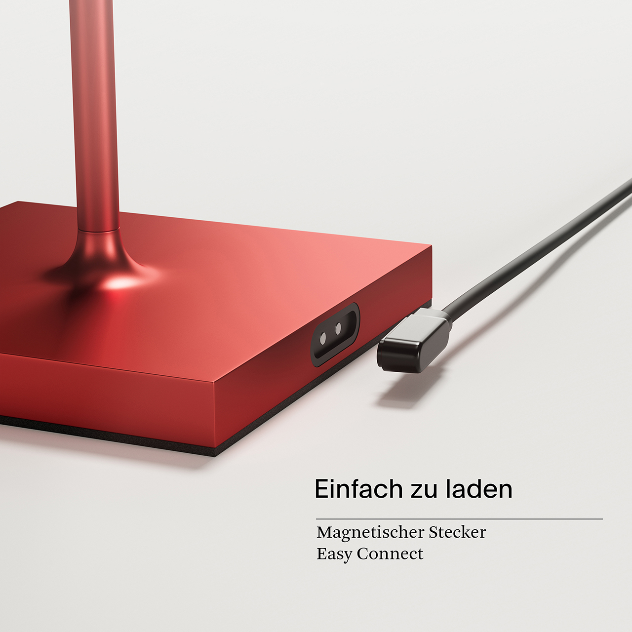 Rote, quadratische Lampe mit schwarzem Ladekabel. Das Kabel ist in den Lampensockel eingesteckt.