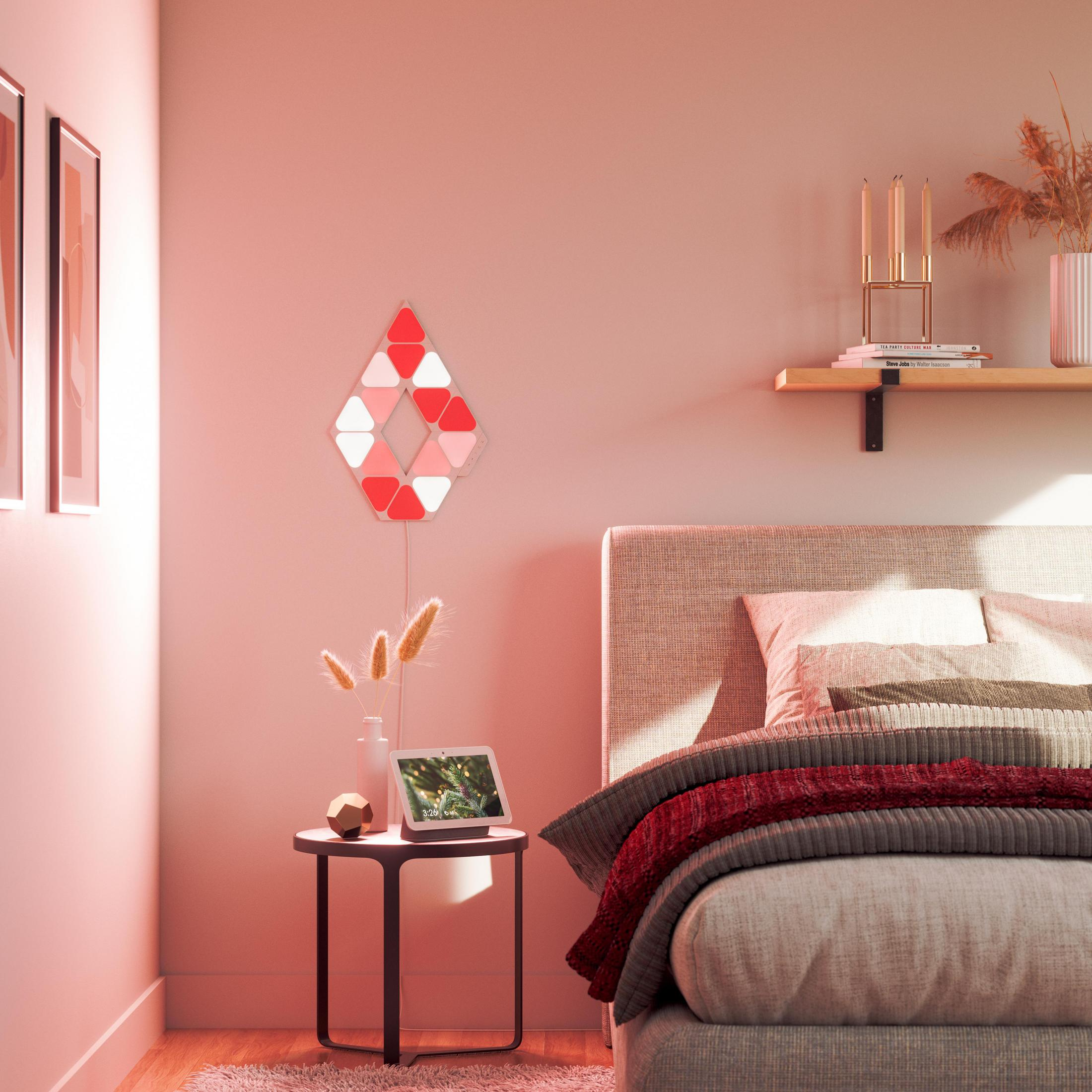 Scena della camera da letto con decorazione murale illuminata di rosso, lampada da tavolo e letto con coperta rossa.