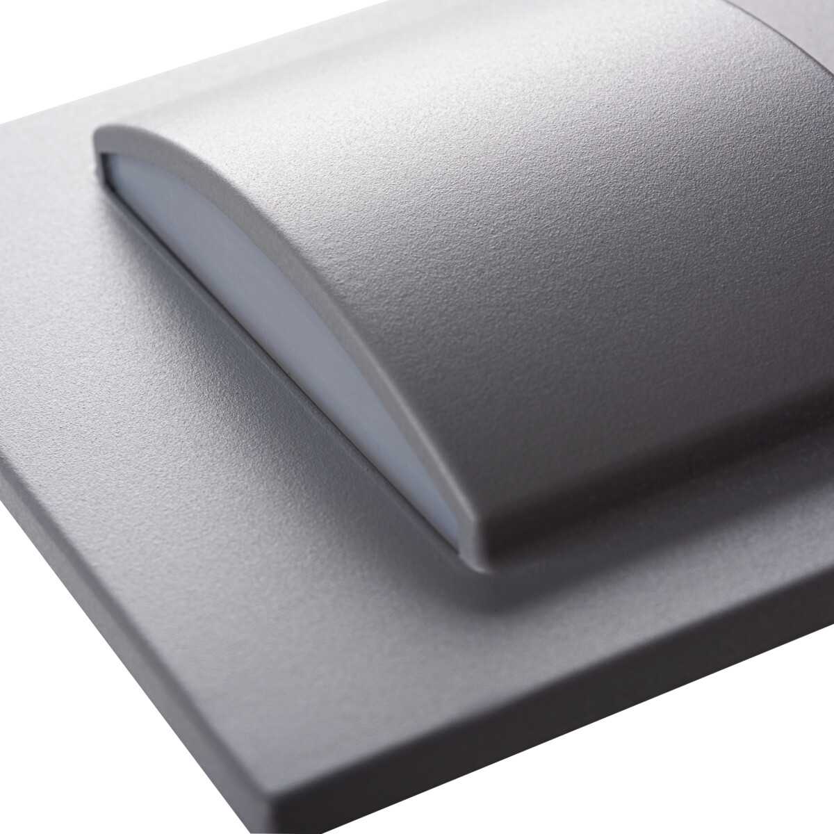 Primer plano de una lámpara gris con luz blanca que emana de la superficie curva.