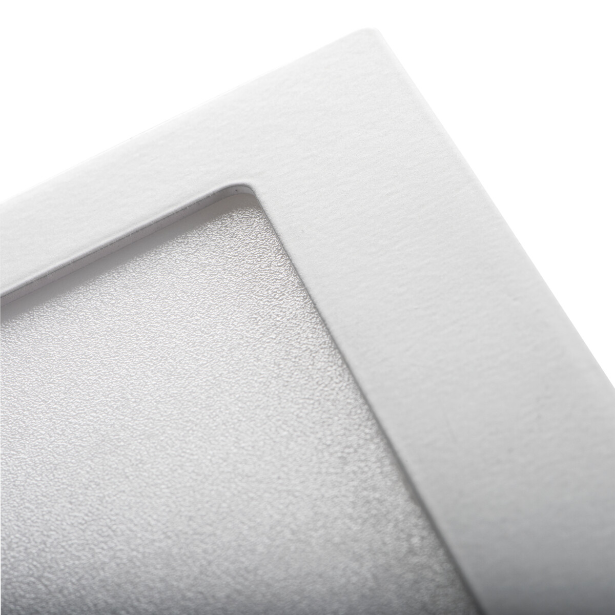 Primo piano di un angolo di un apparecchio di illuminazione, che mostra la texture e i dettagli del bordo.