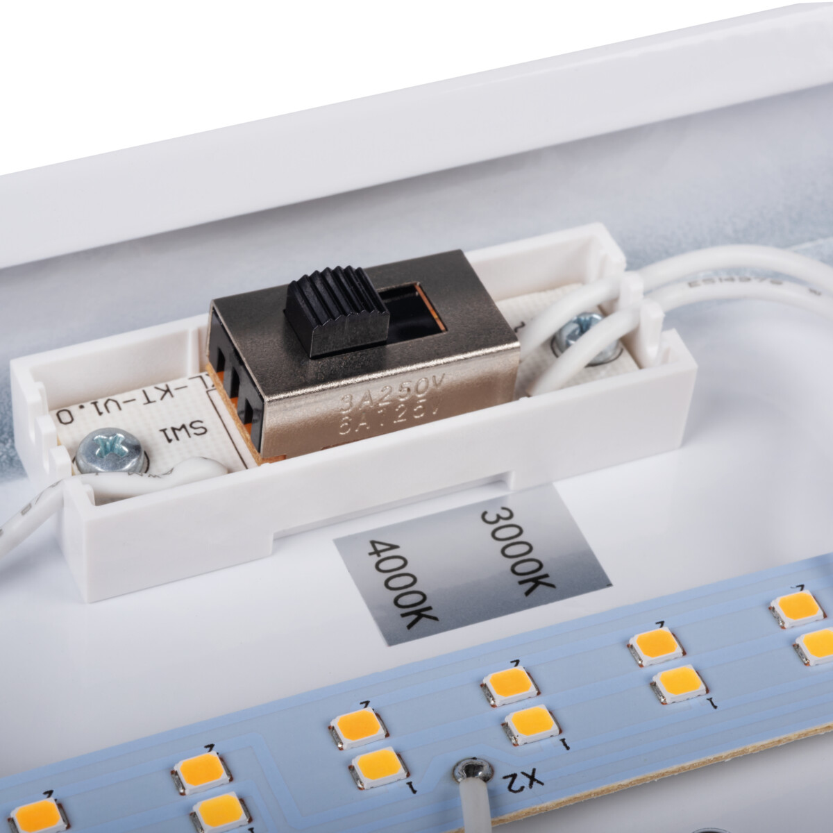 Primo piano dell'interruttore all'interno della lampada LED. Ci sono fili, un interruttore e altri componenti.