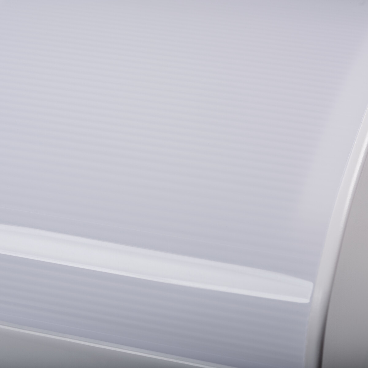 Un oggetto bianco con linee orizzontali, un primo piano. L'oggetto è curvo.